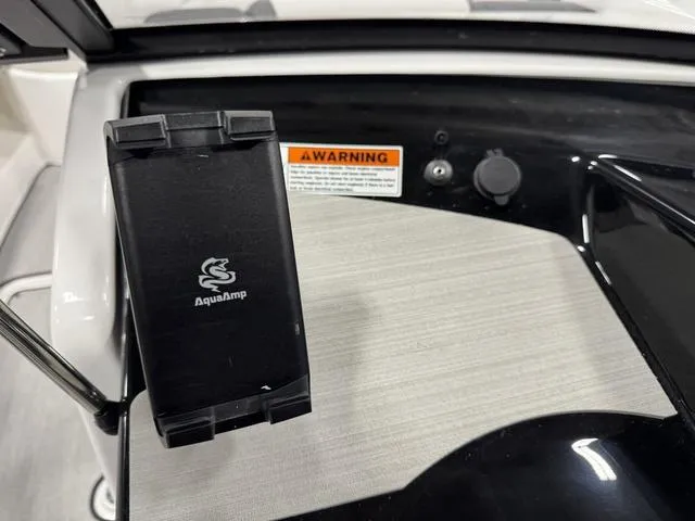 Slide: The Image of 2025 Yamaha Boats AR220 dashboard featuring AquaAmp device and warning label. - 8