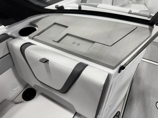 Slide: The Image of 2025 Yamaha AR220 boat interior with wireless charging pad and sleek storage compartment. - 9
