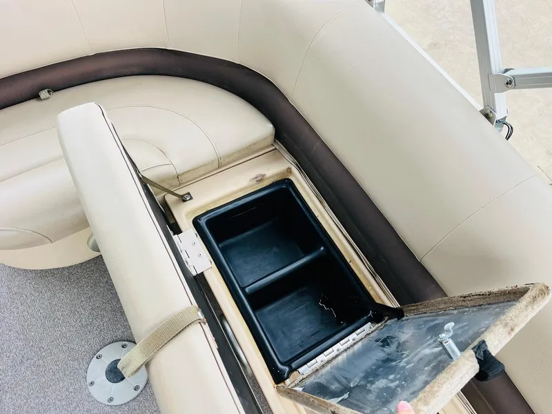 Slide: The Image of Open storage compartment on 2017 Sun Tracker Fishin' Barge 22 XP3 boat with beige seating. - 22