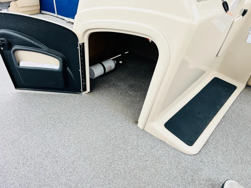 Slide: The Image of 2017 Sun Tracker Fishin' Barge 22 XP3 interior with open storage compartment and fire extinguisher. - 27