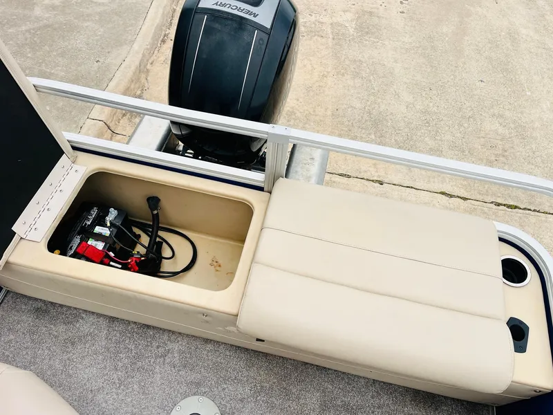 Slide: The Image of 2017 Sun Tracker Fishin' Barge 22 XP3 with open storage compartment and visible outboard motor. - 38