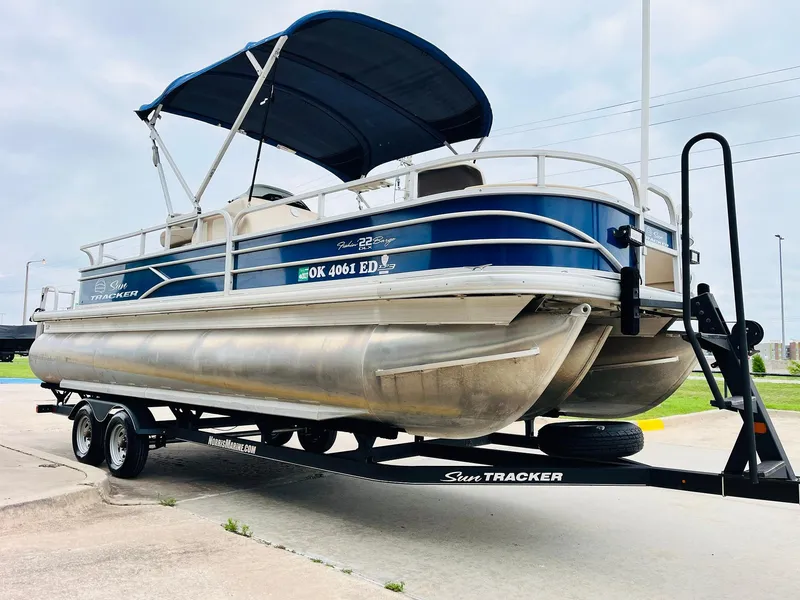 Slide: The Image of 2017 Sun Tracker Fishin' Barge 22 XP3 pontoon boat on trailer, blue canopy. - 4