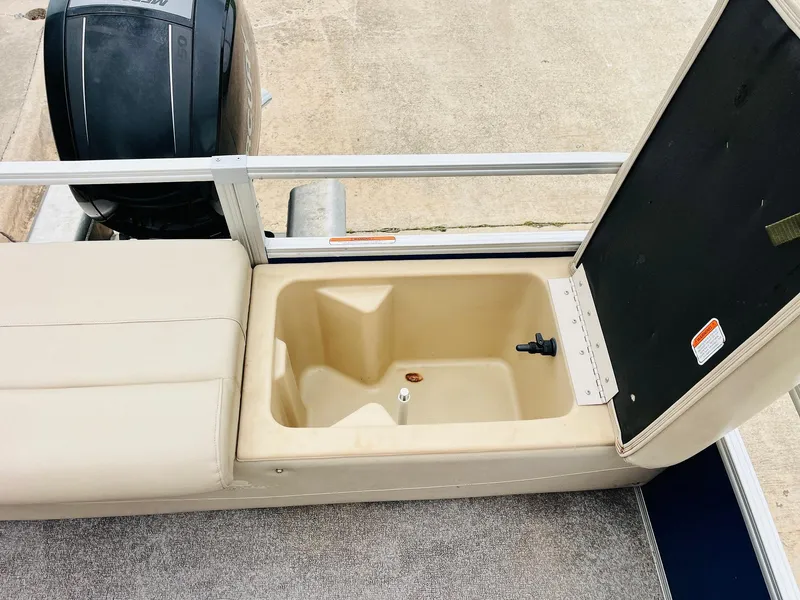 Slide: The Image of 2017 Sun Tracker Fishin' Barge 22 XP3 with open storage compartment and outboard motor. - 40