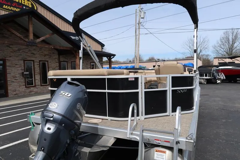 Slide: The Image of 2016 Bennington 22 SLX pontoon boat with Yamaha outboard motor in a parking lot. - 3