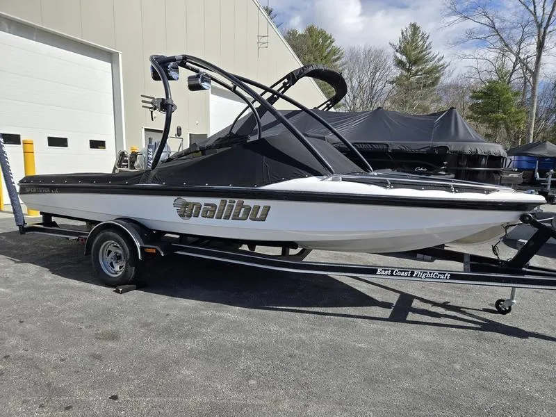 Slide: The Image of 2001 Malibu Sportster boat on trailer, parked outdoors near a building. - 6