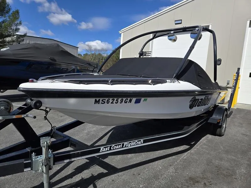 Slide: The Image of 2001 Malibu Sportster boat on trailer, parked outdoors under a clear blue sky. - 7