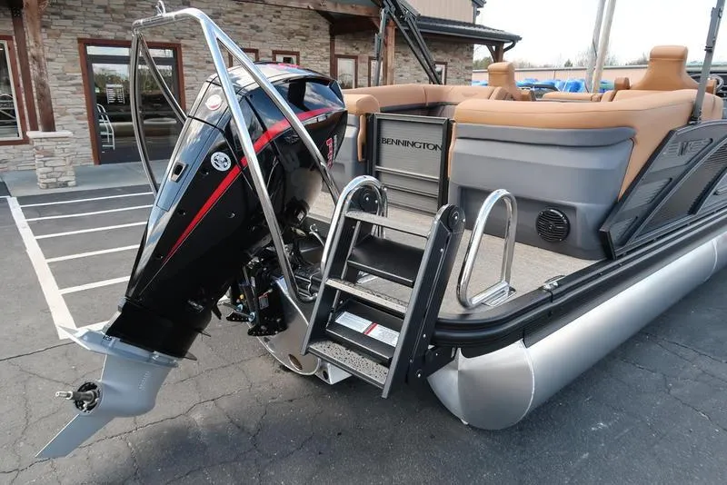 Slide: The Image of 2025 Bennington M Quad Bench 24 MFB pontoon boat with outboard motor and ladder. - 18