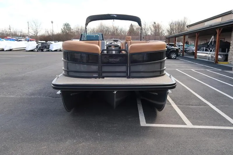 Slide: The Image of 2025 Bennington M Quad Bench 24 MFB pontoon boat in parking lot, rear view. - 2