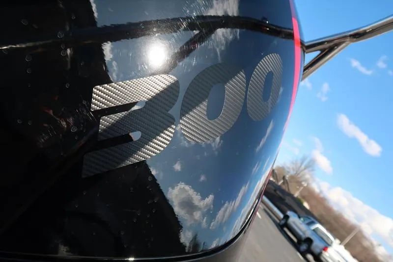 Slide: The Image of Close-up of Bennington M Quad Bench 24 MFB 2025 with "300" decal, reflecting sky. - 20