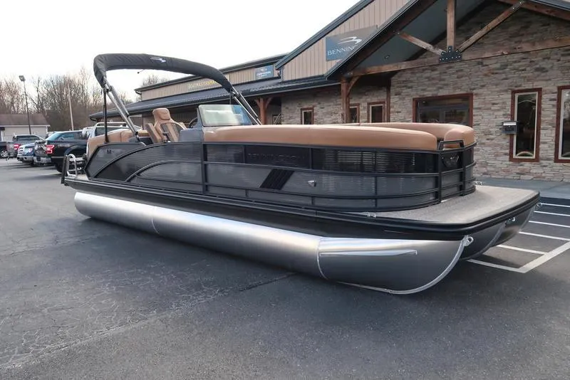 Slide: The Image of 2025 Bennington M Quad Bench 24 MFB pontoon boat parked outside dealership. - 4