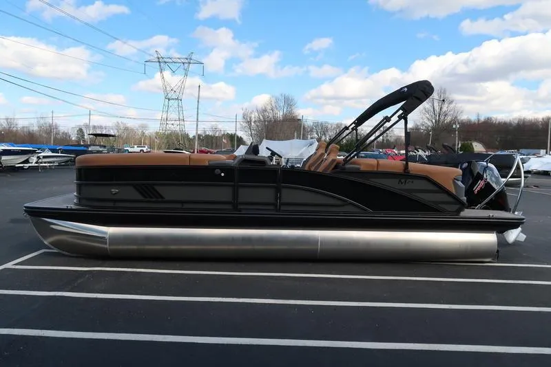 Slide: The Image of 2025 Bennington M Quad Bench 24 MFB pontoon boat in parking lot under blue sky. - 5