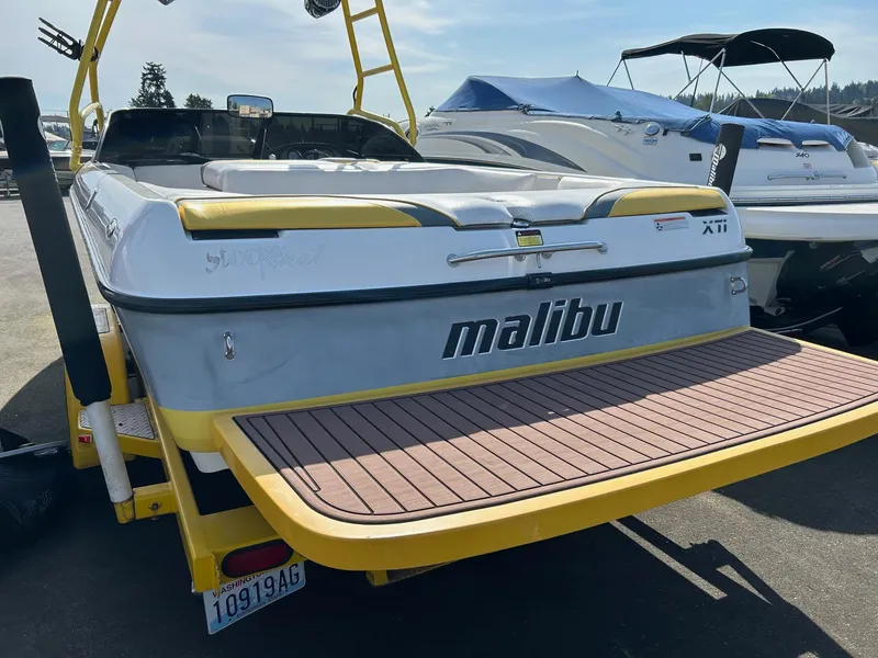 Slide: The Image of 2002 Malibu Wakesetter 21 XTi boat with yellow accents and swim platform. - 1