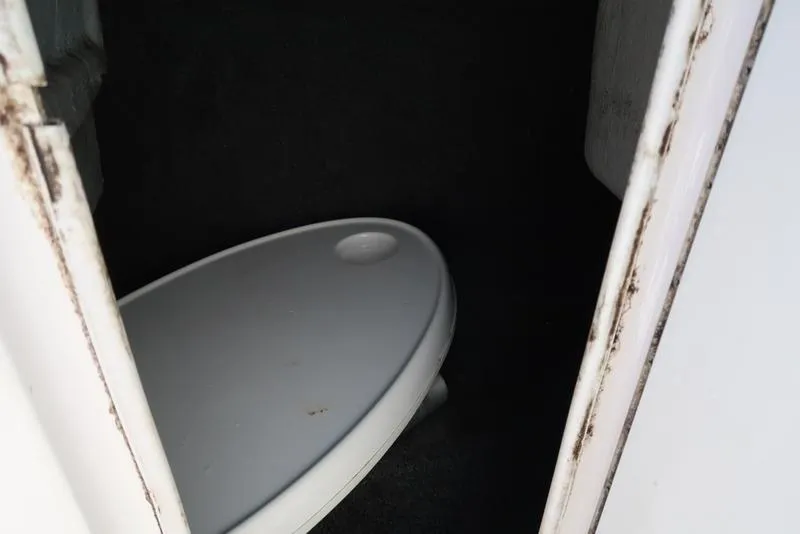 Slide: The Image of 2004 Yamaha Boats SX 230 interior showing a compact toilet area. - 18