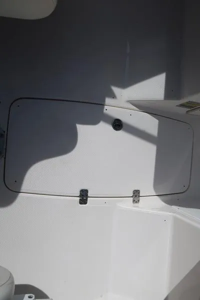 Slide: The Image of 2004 Yamaha Boats SX 230 interior compartment with white panel and latch. - 20