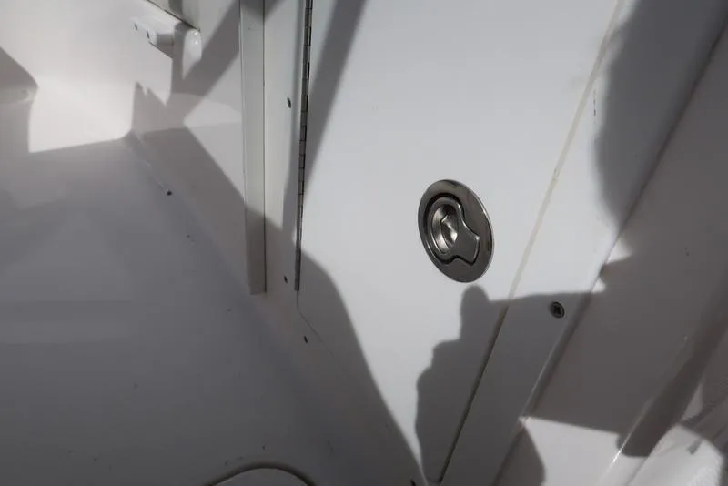 Slide: The Image of 2004 Yamaha Boats SX 230 interior detail with a metal latch on a white surface. - 21