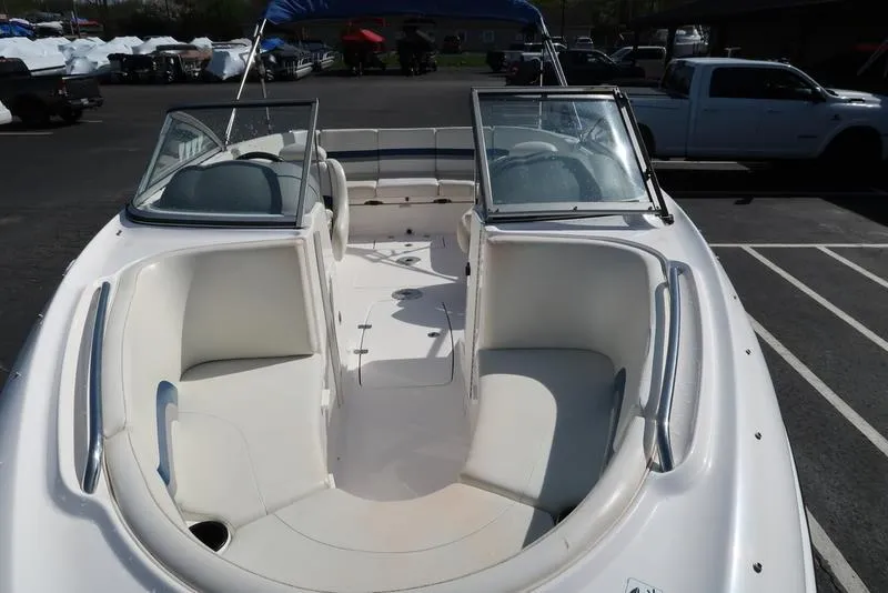 Slide: The Image of 2004 Yamaha Boats SX 230 with open bow seating and windshield, parked in a lot. - 5