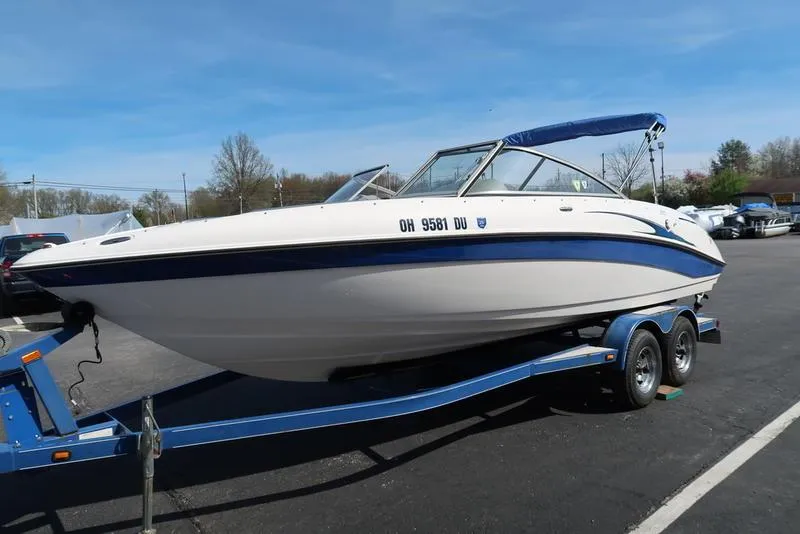 Slide: The Image of 2004 Yamaha Boats SX 230 on trailer, parked outdoors, blue and white design. - 6