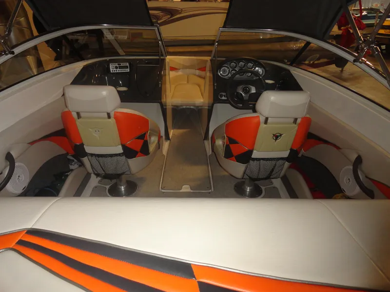 Slide: The Image of 2005 Campion Chase 550I BR boat interior with orange and black seating, dashboard, and steering wheel. - 5