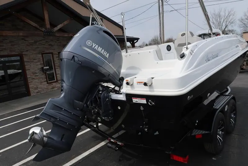 Slide: The Image of 2023 Hurricane SunDeck Sport 188 OB boat with Yamaha outboard motor, parked on trailer. - 10