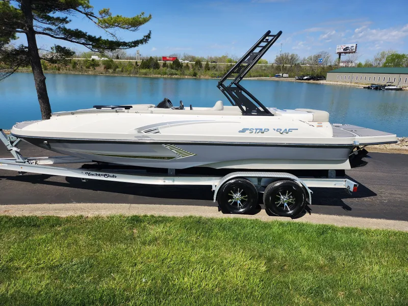 Slide: The Image of 2021 Starcraft Star Step 221 E I/O boat on trailer by a lake. - 11