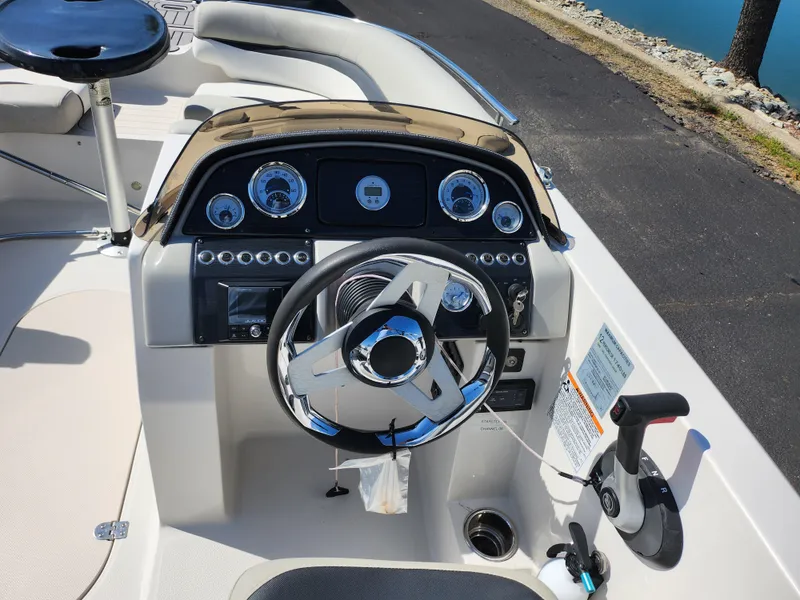 Slide: The Image of 2021 Starcraft Star Step 221 E I/O boat dashboard with steering wheel and controls. - 24