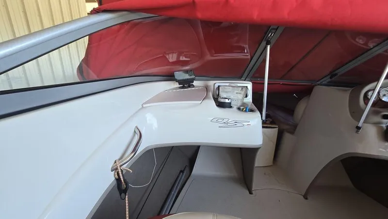 Slide: The Image of 2014 Tahoe Q5i boat interior with red canopy and dashboard view. - 12