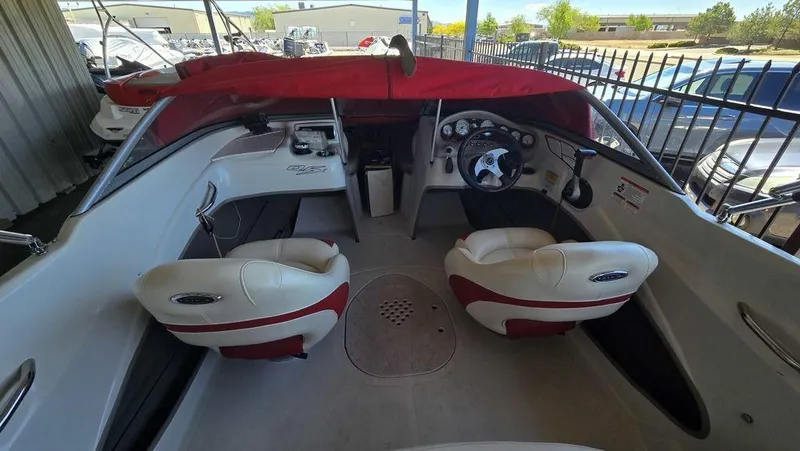 Slide: The Image of 2014 Tahoe Q5i boat interior with red and white seating, steering wheel, and dashboard. - 16