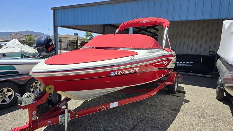 Slide: The Image of 2014 Tahoe Q5i red boat with cover on trailer, parked outdoors. - 4