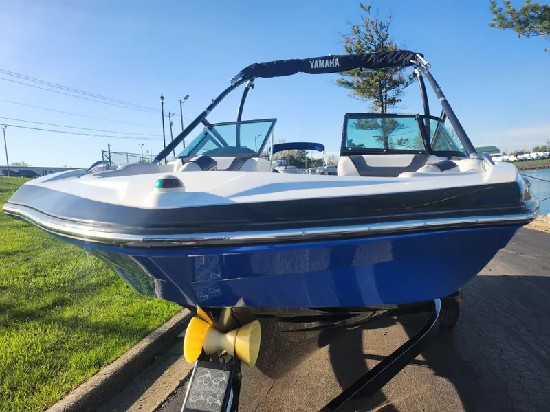 Slide: The Image of 2014 Yamaha AR192 boat with blue hull on a trailer, parked near a grassy area. - 6