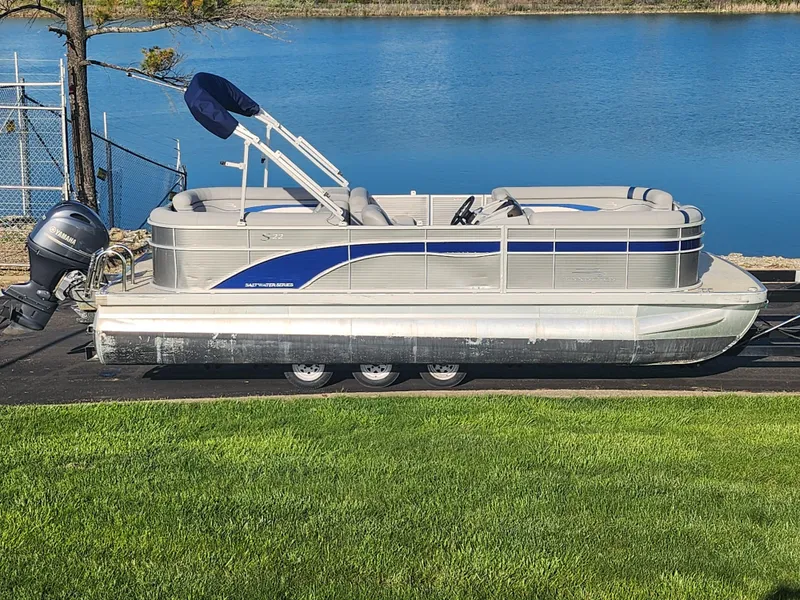 Slide: The Image of 2022 Bennington S 22 L-Bench pontoon boat by a serene lake. - 0