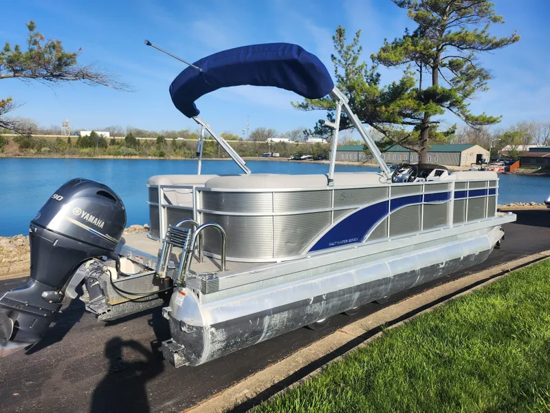 Slide: The Image of 2022 Bennington S 22 L-Bench pontoon boat with Yamaha motor by a lake. - 1
