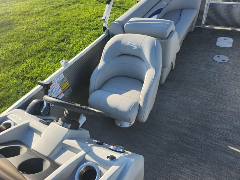 Slide: The Image of 2022 Bennington S 22 L-Bench boat interior with helm and seating on a sunny day. - 18