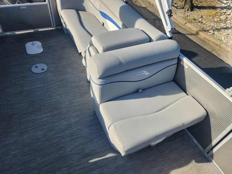 Slide: The Image of 2022 Bennington S 22 L-Bench pontoon boat with gray seating and blue accents. - 20