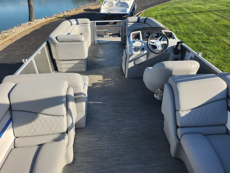 Slide: The Image of 2022 Bennington S 22 L-Bench pontoon boat interior with plush seating and steering console. - 24