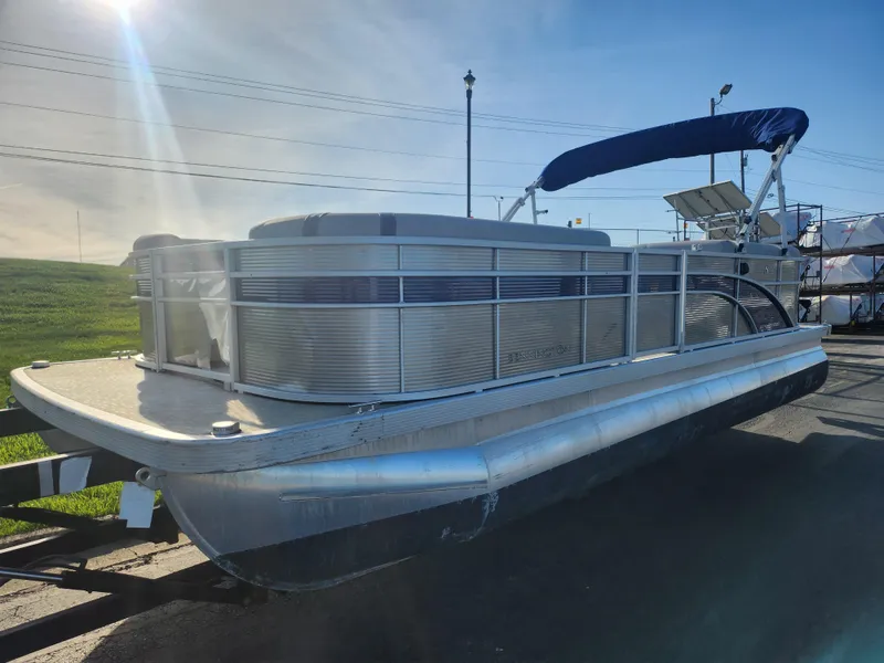 Slide: The Image of 2022 Bennington S 22 L-Bench pontoon boat with blue canopy on a sunny day. - 5
