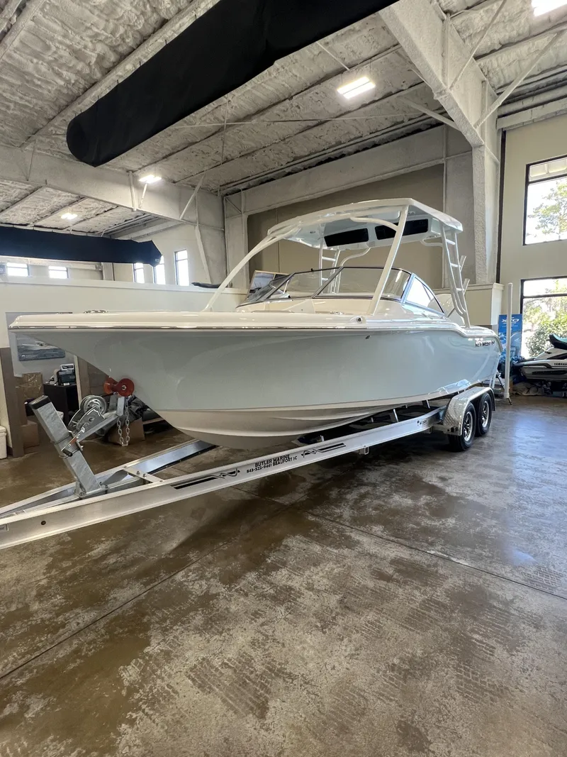 Slide: The Image of 2025 Key West Dual Console 239DFS boat on trailer in indoor showroom. - 2