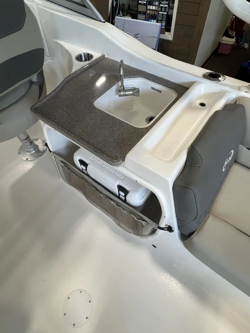 Slide: The Image of 2025 Key West Dual Console 239DFS boat interior with sink and seating area. - 4