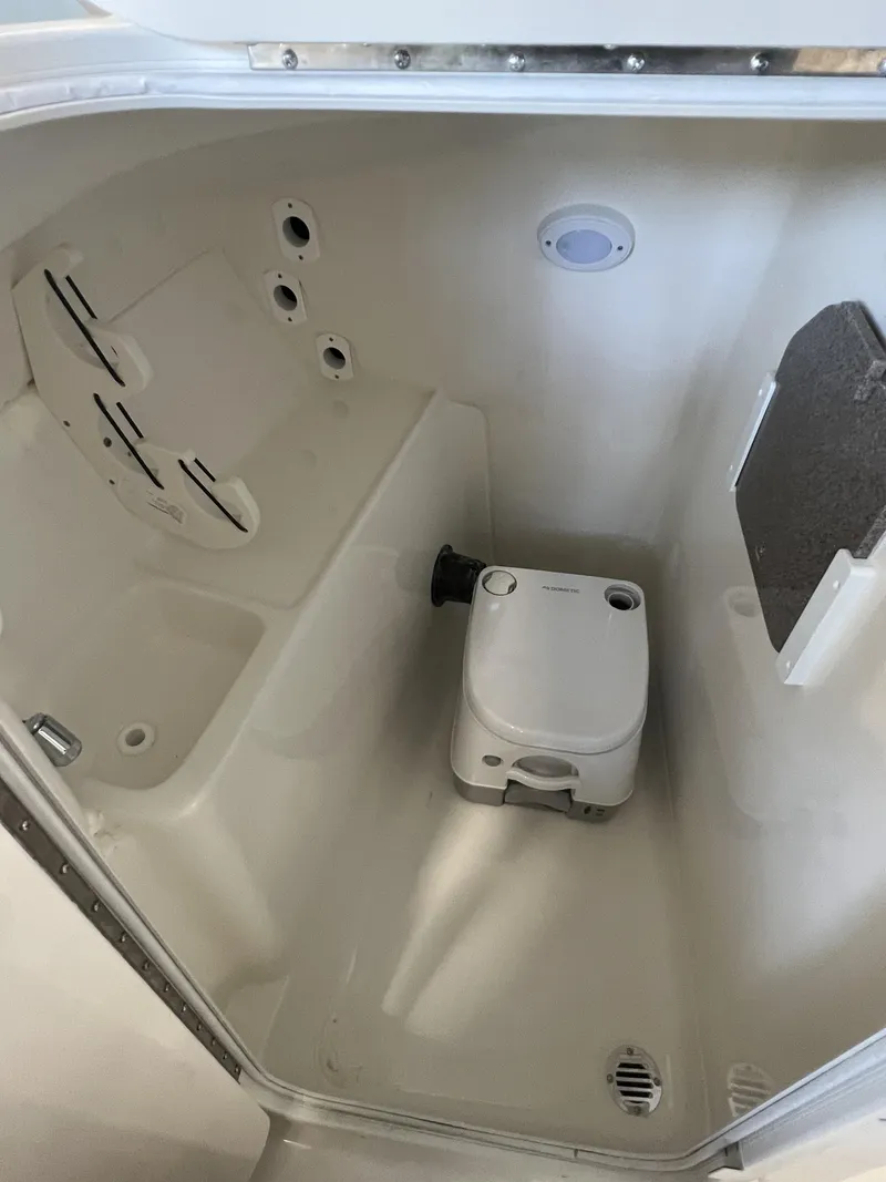 Slide: The Image of 2025 Key West Dual Console 239DFS boat interior with portable toilet. - 9