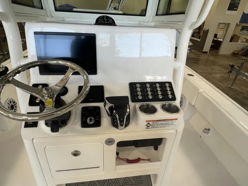 Slide: The Image of 2024 Caymas HB 26 boat console with steering wheel, controls, and display screen. - 3