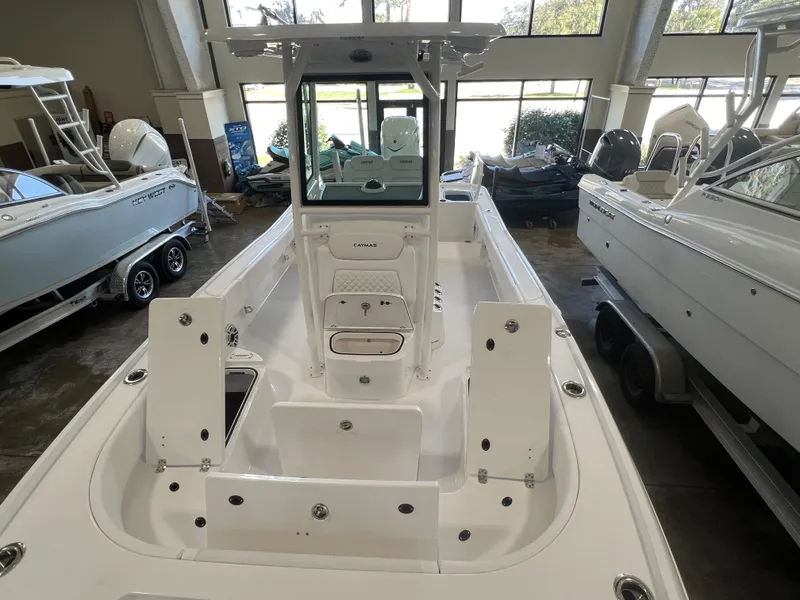Slide: The Image of 2024 Caymas HB 26 boat interior in showroom, featuring sleek white design and modern amenities. - 7