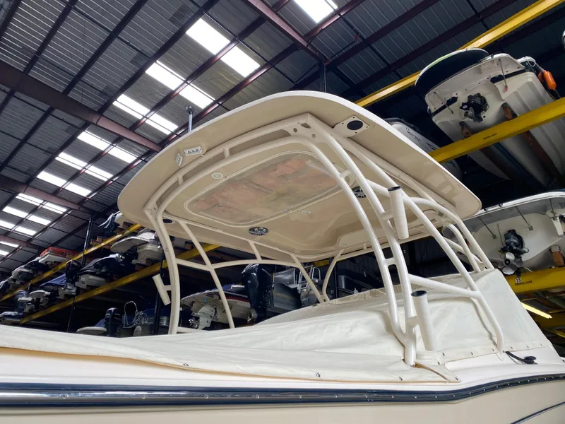 Slide: The Image of 2021 Grady-White Freedom 275 boat in storage, showcasing its sturdy canopy and sleek design. - 11