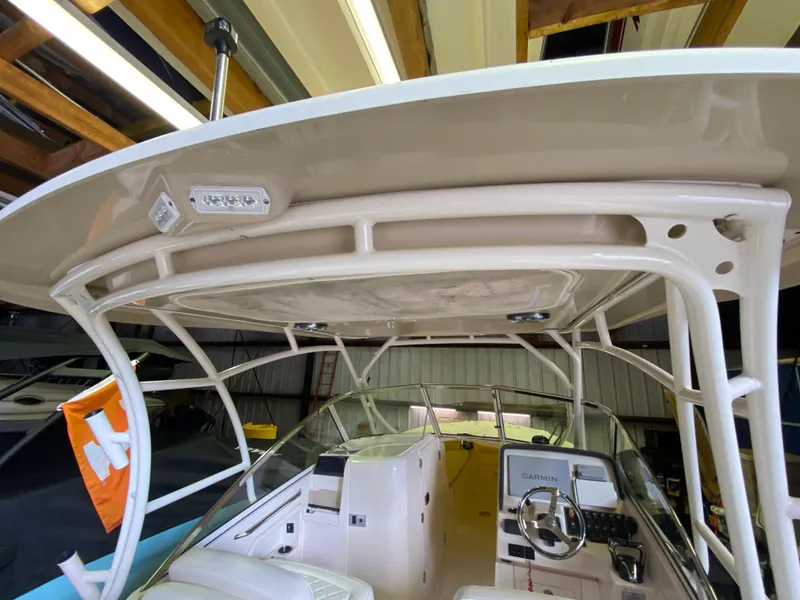 Slide: The Image of 2021 Grady-White Freedom 275 boat interior with helm and hardtop in a storage facility. - 20