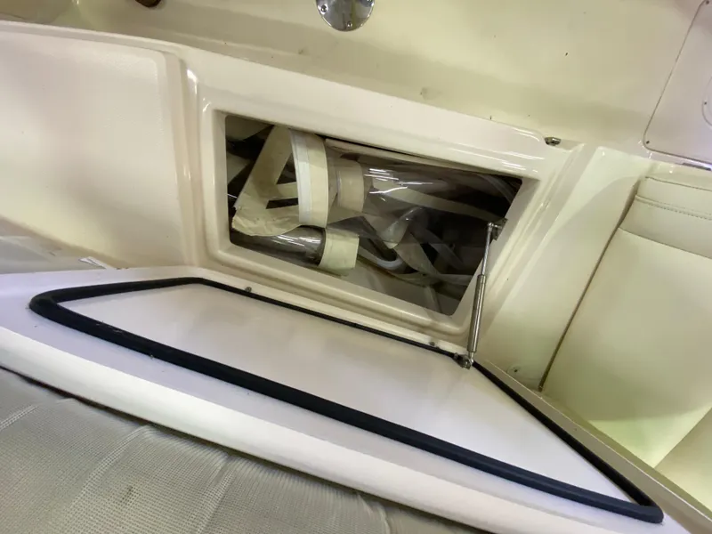 Slide: The Image of 2021 Grady-White Freedom 275 boat storage compartment with open hatch and visible straps. - 29