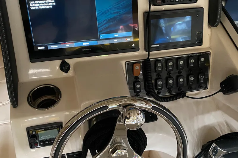 Slide: The Image of 2021 Grady-White Freedom 275 dashboard with steering wheel and electronic controls. - 32