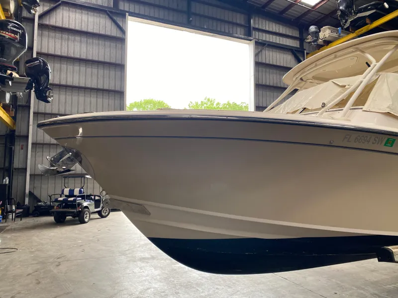 Slide: The Image of 2021 Grady-White Freedom 275 boat in a warehouse, front view. - 4