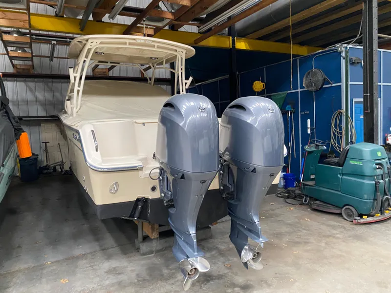 Slide: The Image of 2021 Grady-White Freedom 275 boat with dual outboard motors in a storage facility. - 6
