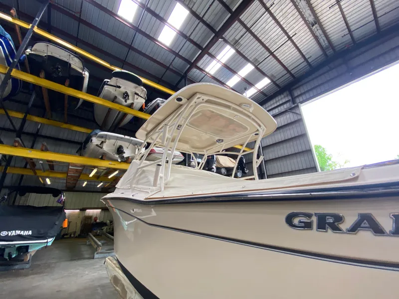 Slide: The Image of 2021 Grady-White Freedom 275 boat stored in a covered marina with other vessels. - 8