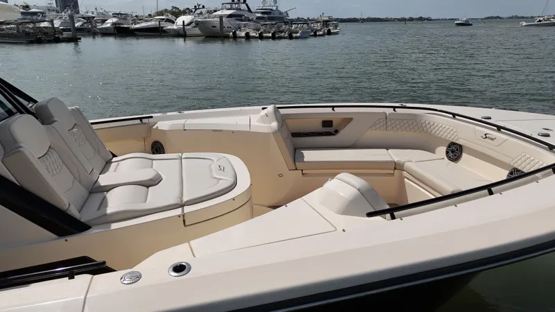 Slide: The Image of 2024 Scout 377 LXF luxury boat interior with spacious seating, docked in a marina. - 6