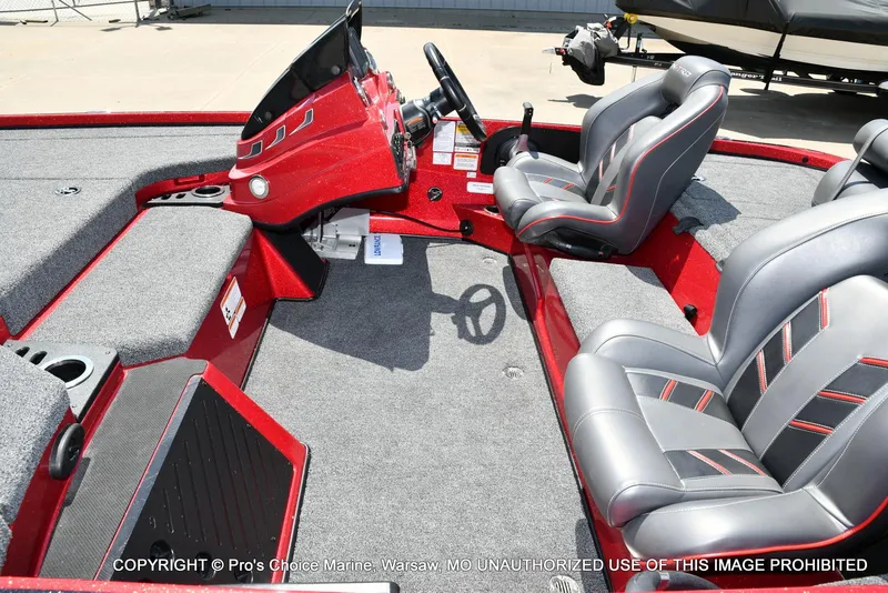 Slide: The Image of 2021 Nitro Z18 boat interior with gray and red seating, steering console, and carpeted flooring. - 15