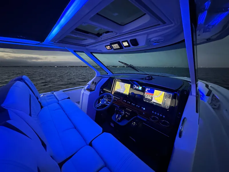 Slide: The Image of 2020 Tiara Yachts 43 LS cockpit with blue ambient lighting and advanced navigation displays. - 15